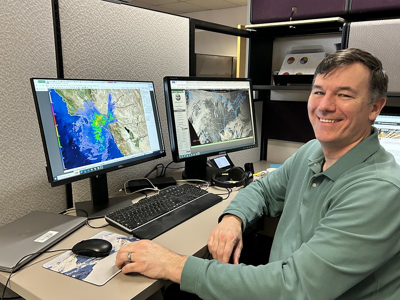 Photo of a meteorologist at his computer providing predictive services