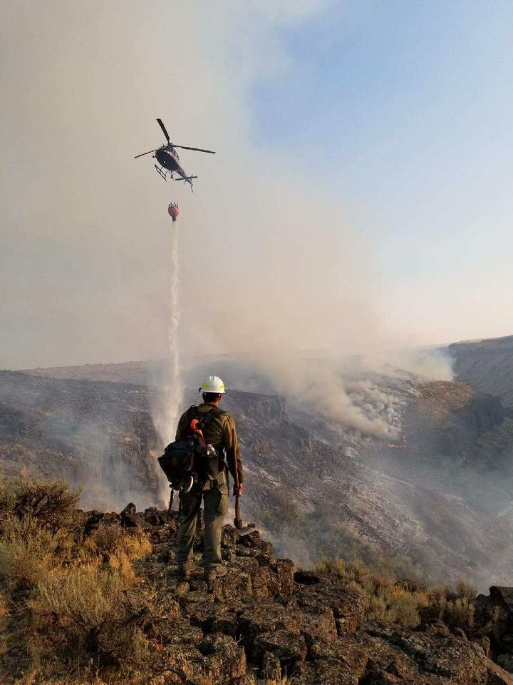 Photo of firefighter watching helicopter drop water on 2017 Rim Fire in Idaho